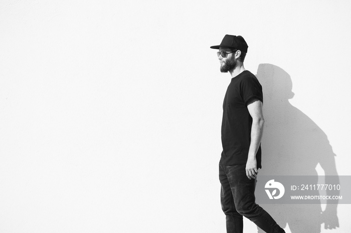 Hipster man walking along a wall wearing black clothes