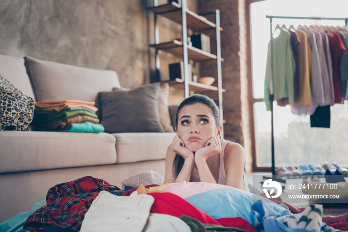 Photo of pretty stressed crying lady stay home quarantine lying many clothes heap stack floor wardrobe stuff pick select date look outfit nothing to wear concept living room indoors