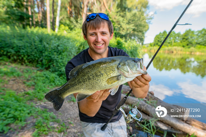 Bass fishing. Fisherman holding largemouth perch fish