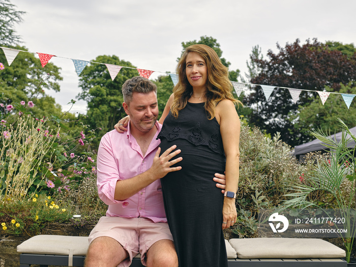 Portrait of pregnant couple in garden