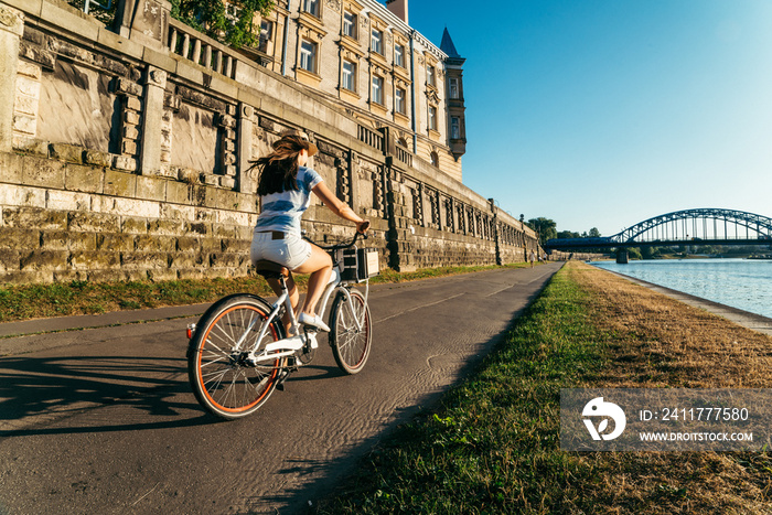 pretty woman ride bicycle on embankment of Wisla river