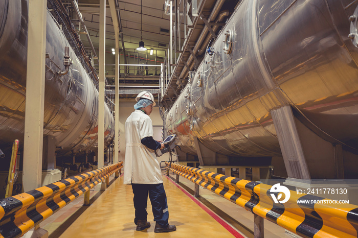 Male work inspection process milk powder cellar at the with horizontal stainless steel tanks