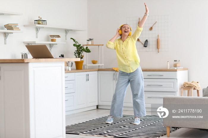 Cool young woman listening to music and dancing at home