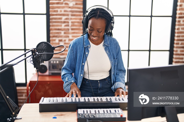 African american woman musician playing piano keyboard at music studio