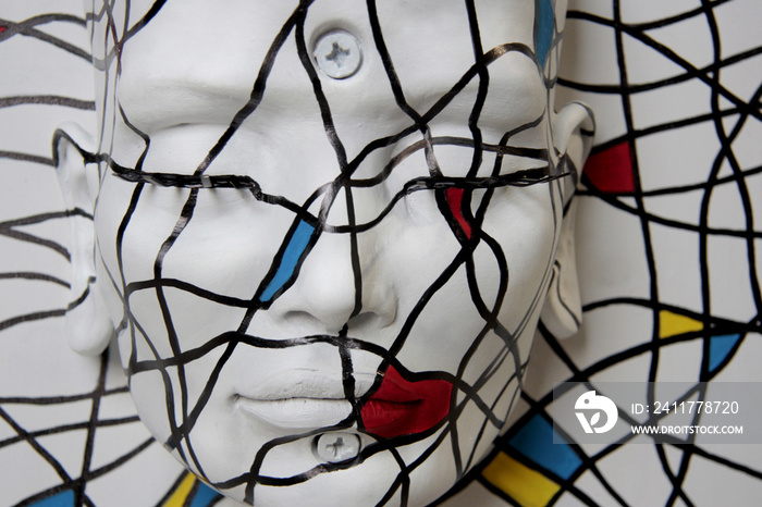 White statue face. Sculpture of female, beautiful features with closed eyes. Abstract texture, primary colors.