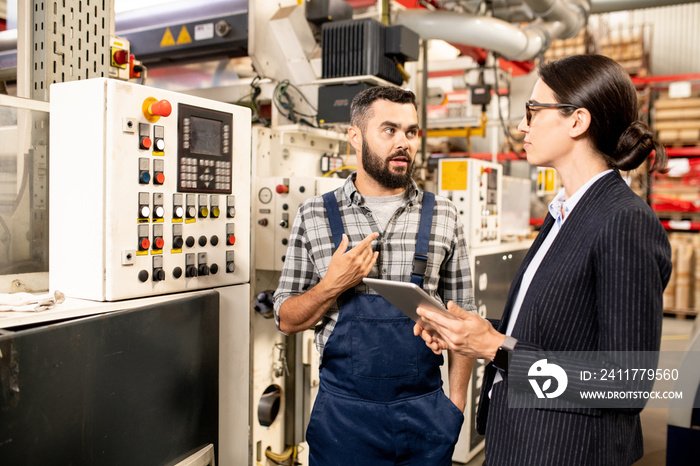 Engineer of processing factory explaining something to female business partner