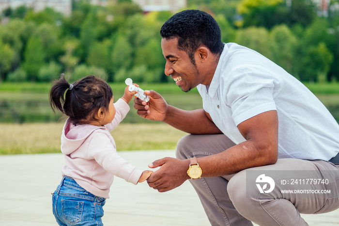 happy family applying hand-sanitizer anti-bacterial gel to daughter hands