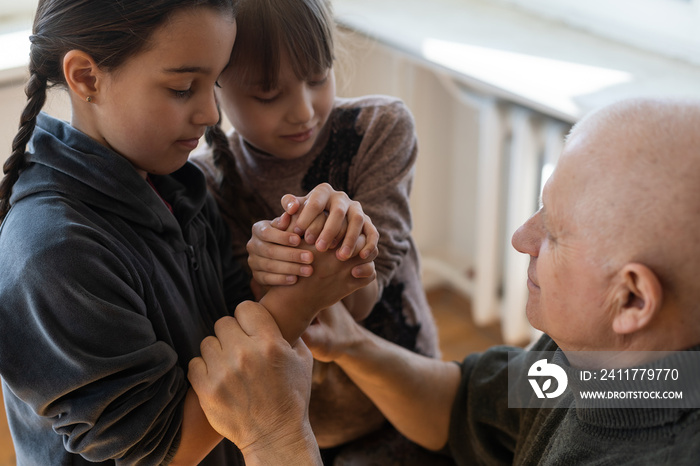 hands of grandfather and granddaughter with prayer