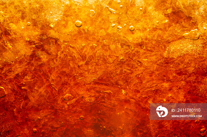 Close up view of the ice cubes in dark cola background. Texture of cooling sweet summer’s drink with foam and macro bubbles on the glass wall. Fizzing or floating up to top of surface.