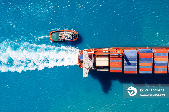 Tugboat parks in port Cargo ship with containers against blue sea, top view. Logistics delivery concept