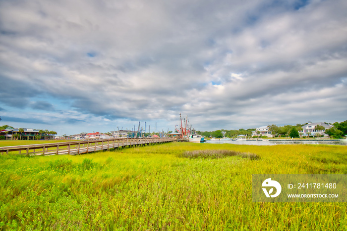 Shrimp boats in Shem creek and a boardwalk across the marsh, near Charleston, SC.