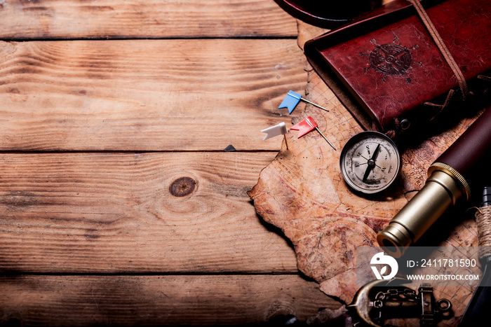 Columbus Day. Pirates and treasure with worldmap and discovery equipment. Copy space on dark background.