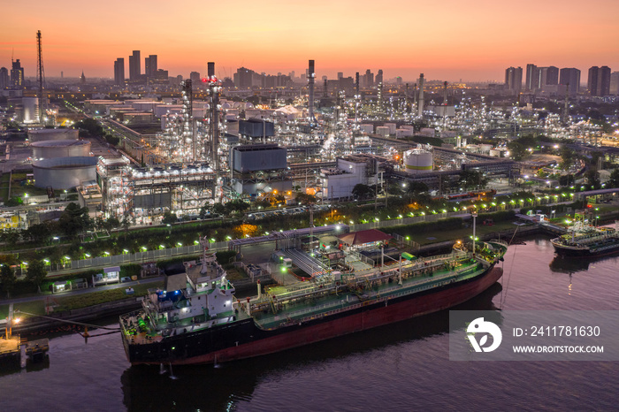 Aerial view Oil ship tanker load or unload oil at loading dock from refinery at dusk.