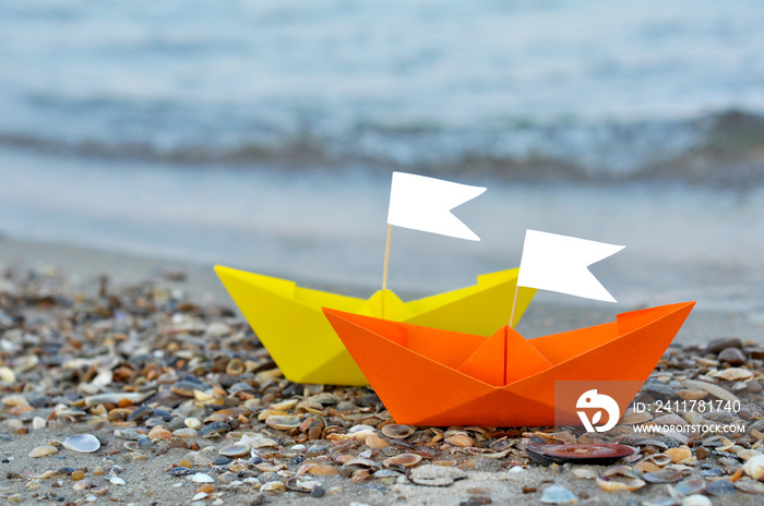 Paper boat near sea. origami paper sailboat ready to sail on blue water. Unusual travel concept