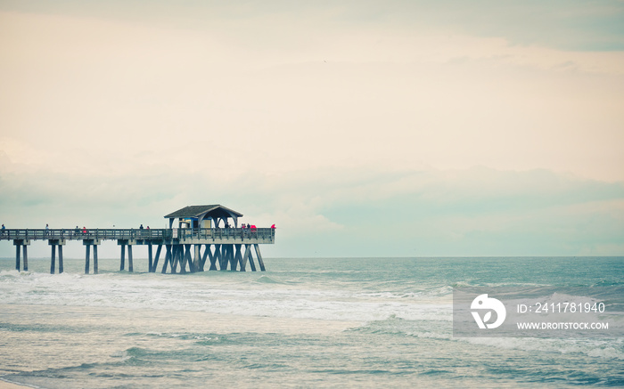 Vacationers fish from Tybee Island Fishing Pier on a cloudy day.