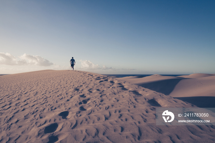 Man is running on sand dunes in Maspalomas.