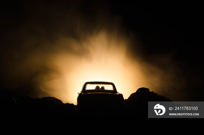 silhouette of car with couple inside on dark background with lights and smoke. Romantic scene. Love concept