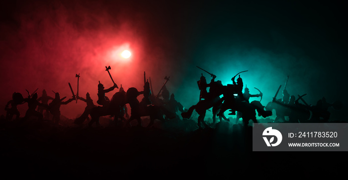 Medieval battle scene with cavalry and infantry. Silhouettes of figures as separate objects, fight between warriors on dark toned foggy background. Night scene.