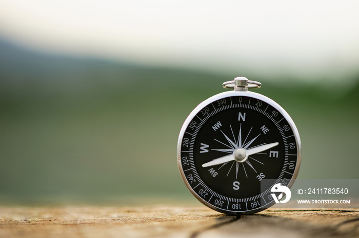 Classic compass on a wooden vintage with a green background. compass for a symbol of tourism with compass, travel with a compass, life direction concept.