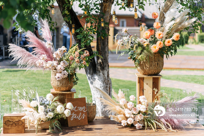 Outdoor wedding ceremony. Composition of chrysanthemums, pampas grass and roses