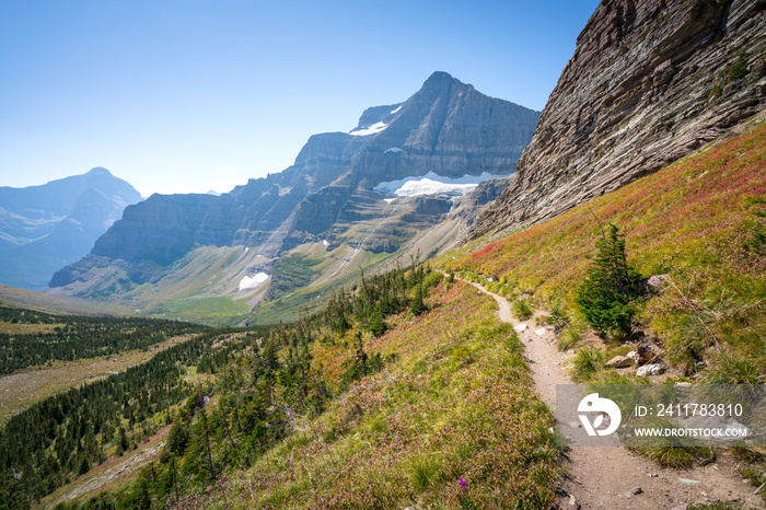 Matahpi Peak and valley below viewed from Siyeh Pass hiking trail, Glacier National Park, Montana. Sunny summer day high in American Rockies. Mountain range and valley bellow on a sunny day.