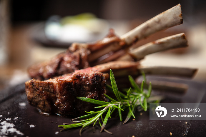 Grilled lamb chops served with a branch of rosemary