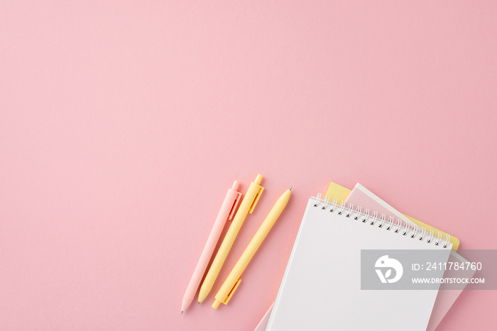 Back to school concept. Top view photo of school supplies stack of notebooks and pens on isolated pink background with empty space