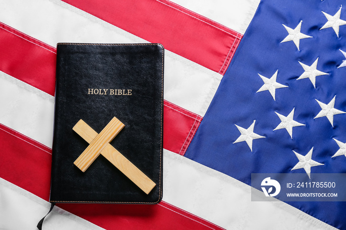 Holy Bible with wooden cross on flag of USA