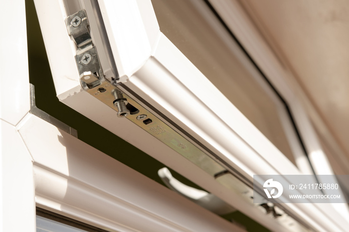 Shallow focus of a new double glazing window system at the back of a house. Details of the new security bolt system and latching is seen in the opened window.