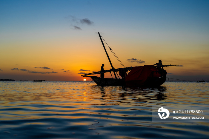 Traditional fisherman dhow boat during sunset on Indian ocean in island Zanzibar, Tanzania, East Africa