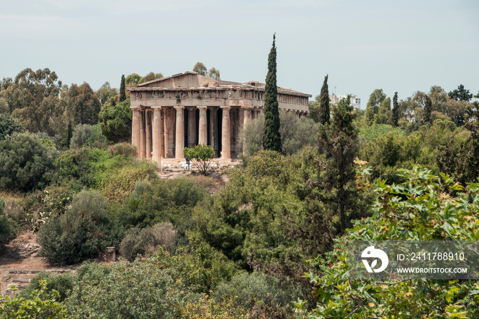 Ancient Temple of Hephaestus surrounded by lush summer vegetation in Athens, Greece