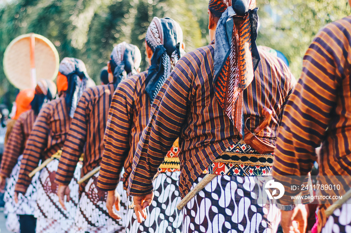 Men wearing traditional Javanese attire with keris, batik, and blangkon to show the richness of Javanese culture at the carnival in Yogyakarta