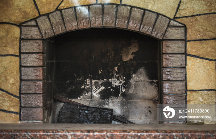 Concrete dirty fireplace with remains of ash after wooden firewood burnt in fireplace