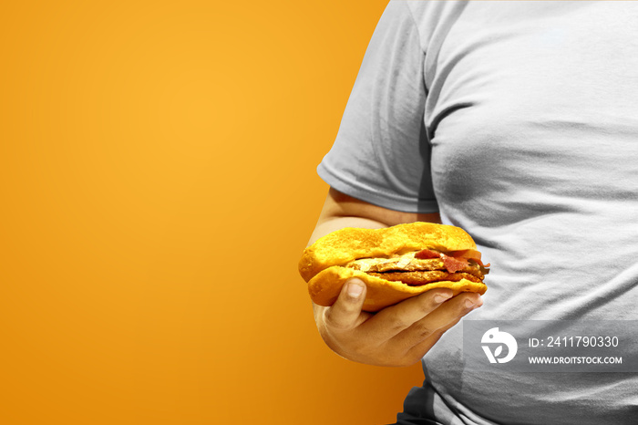 Fat man holding a hamburger with a colored background