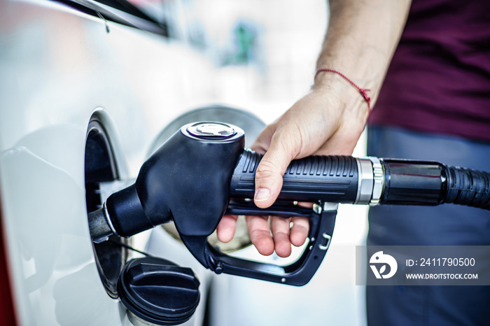 Man fulling tank with fuel at bokeh background