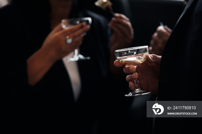 business meeting. successful people in stylish suits holding glasses of alcohol on party, corporate party, conference, forums, banquets, closeup. selective focus. hand with drink of Champagne