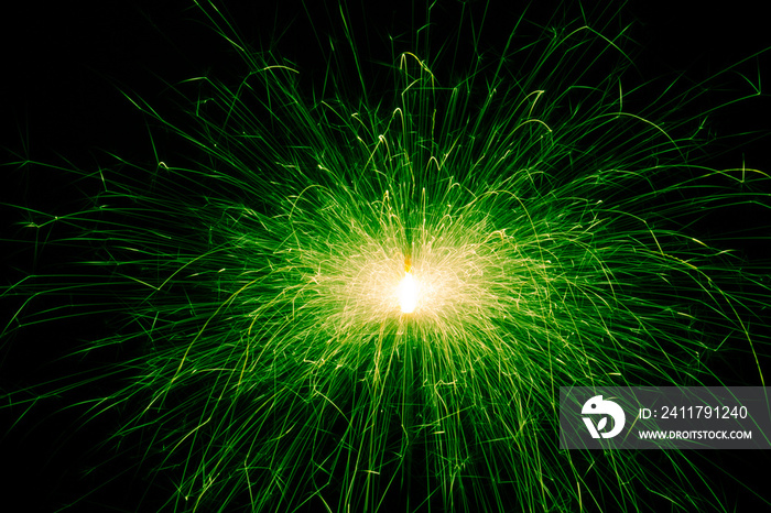 Sparkler, green sparks on a black background. Abstract photo of sparks, holiday lights.