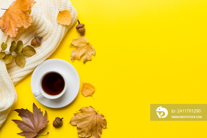 Flat lay composition with colorful Autumn cup of coffee and leaves on a color background. top view