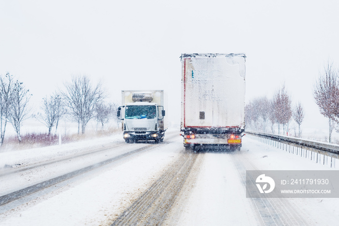 Freight transportation truck on the road in snow storm blizzard