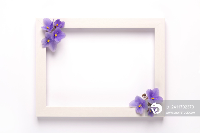 Violet flowers, photo frame on a white background. Top view, copy space. Flat lay.