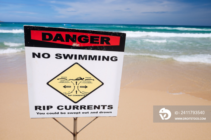 No swimming warning sign on the beach.