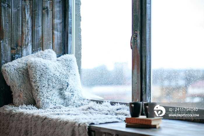 Large window with a window sill. Blankets and books. The concept of rest, relaxation, reading.