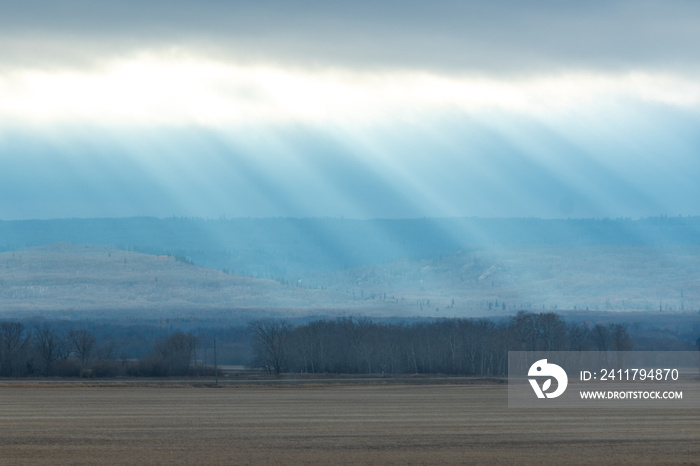 Sun rays shining down brightly over the Canadian prairie lands of Manitoba during autumn fall season in the late afternoon.