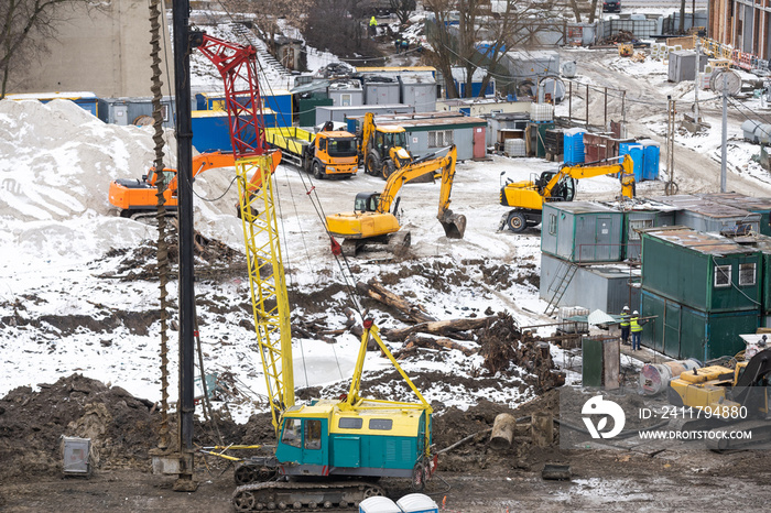 aerial top view of city construction site. tower cranes for building of new apartments under snow in winter