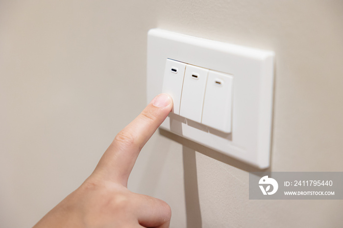 people press light switch to turn off the light for saving home energy reduce utilities billing cost