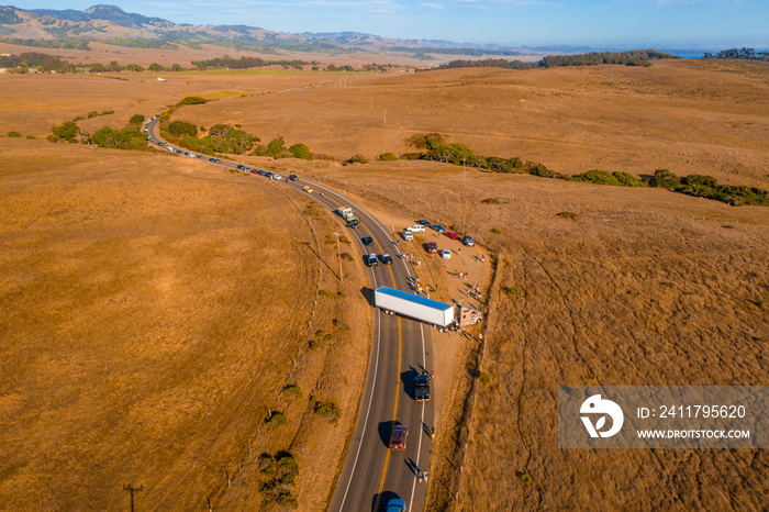 California Highway Traffic. Trucks and cars on the Highway 1 are stuck because of the accident. Huge truck blocked the road both ways. American transportation theme.