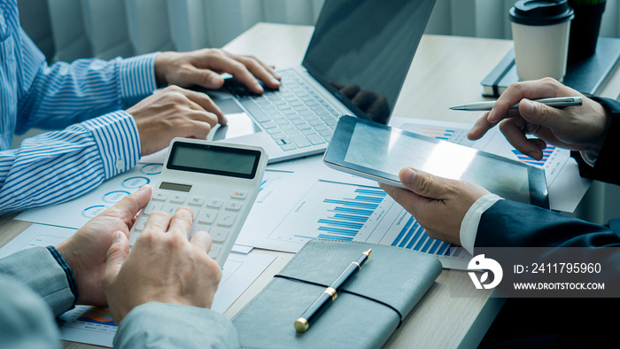 2 businessmen holding pens Point to the graph to calculate the analysis of the company’s financial statements. Work with document graphs Concept image for the stock market, office, tax