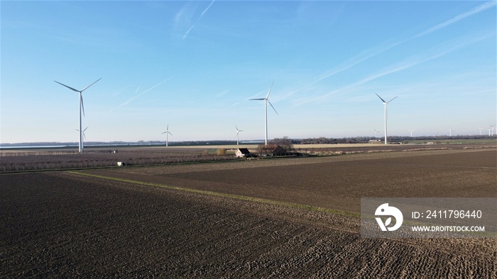 Farmland with farmer’s farm. Bare agricultural landscape of food industry in winter season. Windmills in the background Environment and green environment nature landscape of the countryside.