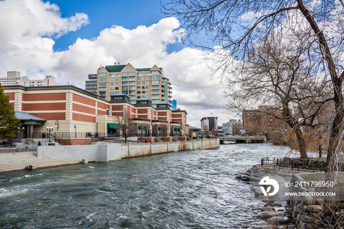 Reno, Nevada skyline as seen from the shoreline of Truckee river flowing through downtown;