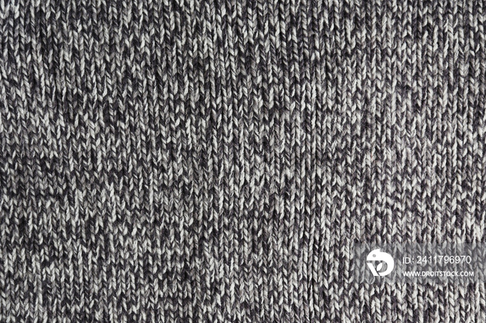 Cropped close up shot of seamless woolen knitting pattern of fall / winter season warm sweater, clearly visible fiber texture of stylish hipster knitwear clothing. Background, copy space, top view.